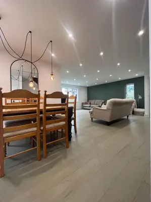 a living room with wooden benches and a couch at Amazing house sleeps 13 in Newlyn East