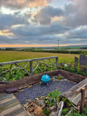 a garden with a blue ball in the middle at Little Swelle Cabin with awesome Sea views in Poundstock