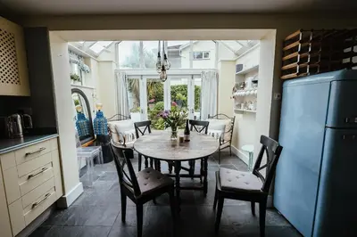 a kitchen with a table and chairs in a kitchen at Roses Cottage in Porthscatho