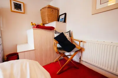 a room with a chair in a room at Roses Cottage in Porthscatho