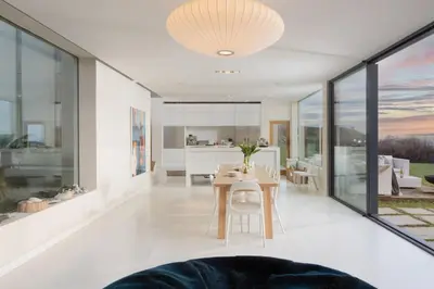 a dining room and living room with a table at Little Cottage and Love Shack in Praa Sands