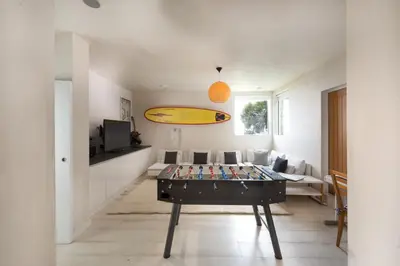 a living room with a table with a surfboard on it at Little Cottage and Love Shack in Praa Sands