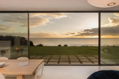 a living room with a view of the ocean at Little Cottage and Love Shack in Praa Sands