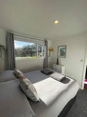 a bedroom with a large bed with a window at Villa 22 Lanteglos Hotel in Lanteglos