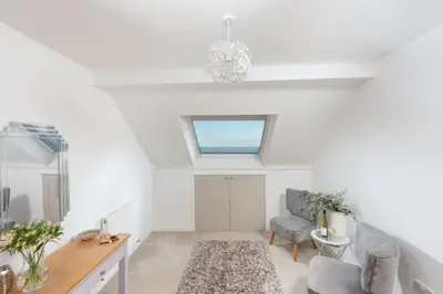 a living room with a window and a chair at Chy an Mor in Coverack