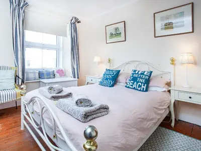a bedroom with a white bed with blue pillows at Tean in Polruan