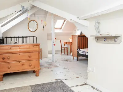 a room with a wooden dresser and a bedroom at Tean in Polruan