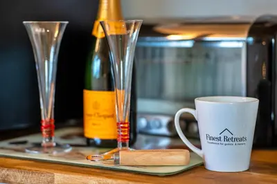 a coffee cup on a tray next to a bottle of wine at Finest Retreats - Treknow Summerhut in Tintagel