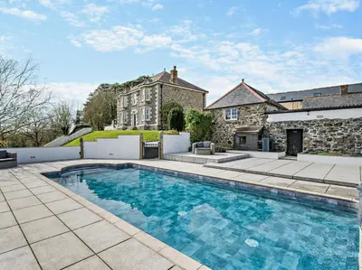 a large swimming pool in front of a house at 1 Bed in Helston oc-41377 in Cury