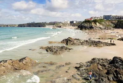 a group of people on a beach with rocks at Mermaid Gaze in Porth, Newquay in Newquay