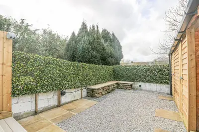 a garden with a hedge and a bench at Sailors in Falmouth
