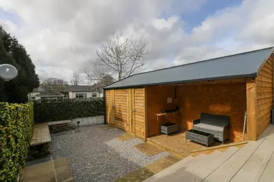 a wooden building with a bench in a courtyard at Sailors in Falmouth