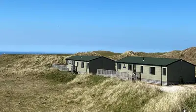 two houses on the side of a sand hill at Perranporth Golf Club Self-Catering Holiday Accommodation in Perranporth