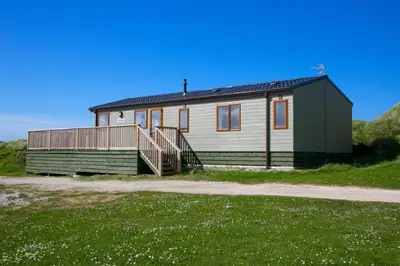 a green and white house with a porch at Perranporth Golf Club Self-Catering Holiday Accommodation in Perranporth