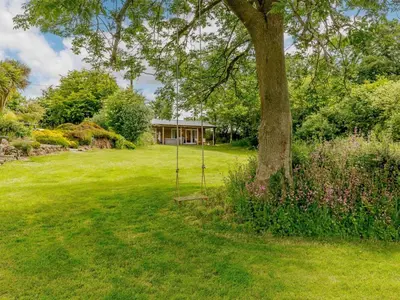 a swing in a yard next to a tree at 1 Bed in Looe oc-88434 in Lanreath