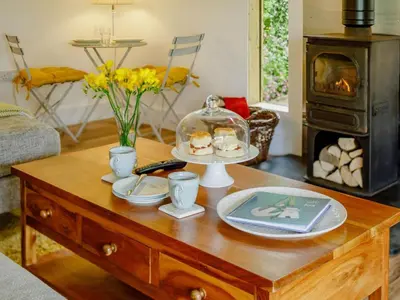 a living room with a coffee table with a stove at 1 Bed in Looe oc-88434 in Lanreath