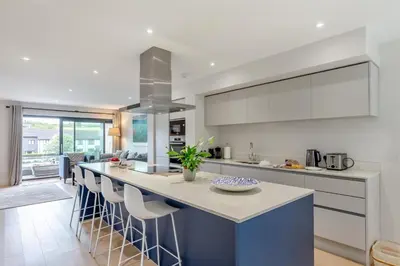 a kitchen with a large island with bar stools at 2 Bed in Harlyn Bay oc-a28321 in St Merryn