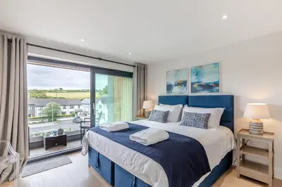 a bedroom with a blue bed and a large window at 2 Bed in Harlyn Bay oc-a28321 in St Merryn