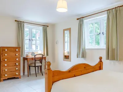 a bedroom with a bed and a table and windows at 2 Bed in Truro oc-ljasm in Saint Allen
