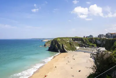 a beach with people on the sand and the ocean at 1 Cliff Edge in Newquay in Newquay