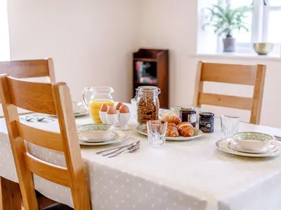 a table with a white table cloth with food on it at 2 Bed in St. Austell oc-79594 in Saint Stephen