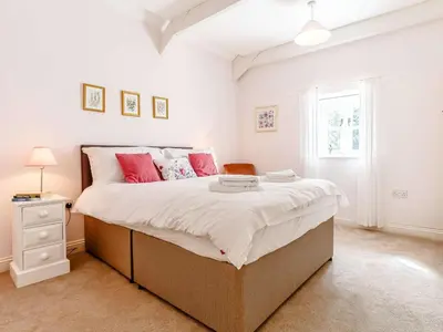 a bedroom with a large bed with pink pillows at 2 Bed in St. Austell oc-79594 in Saint Stephen