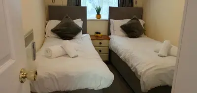 a bedroom with two beds with white pillows at 11 Granite Henge in Pelynt