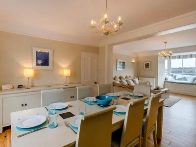 a dining room and living room with a table and chairs at 4 Bed in Polruan oc-pc044 in Fowey