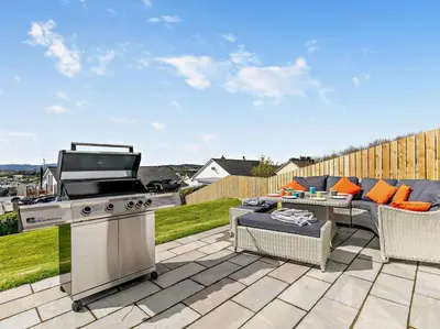 a patio with a grill and a table and chairs at 4 Bed in Fowey oc-91931 in Fowey