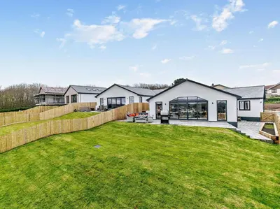 a house with a large yard with a fence at 4 Bed in Fowey oc-91931 in Fowey