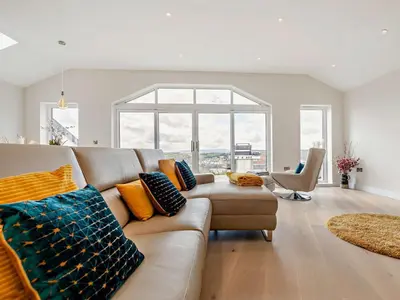 a living room with a couch and a large window at 4 Bed in Fowey oc-91931 in Fowey