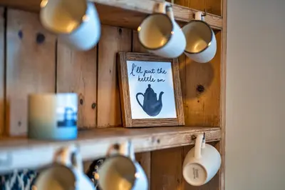 a shelf with cups and a sign that says im not the auntie anymore at Finest Retreats - The Old Counting House in Gweek