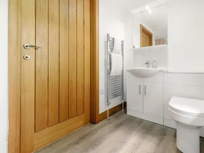 a bathroom with a toilet and a sink at 4 Bed in Callington oc-54343 in Linkinhorne