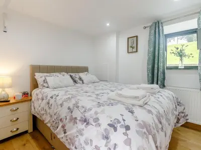 a bedroom with a bed and a window at 4 Bed in Callington oc-54343 in Linkinhorne