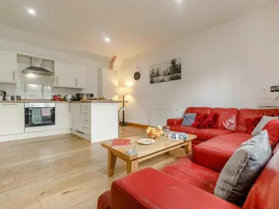 a living room with a red couch and a table at 1 Bed in Callington oc-54344 in Linkinhorne