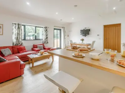 a living room with a red couch and a table at 1 Bed in Callington oc-54344 in Linkinhorne