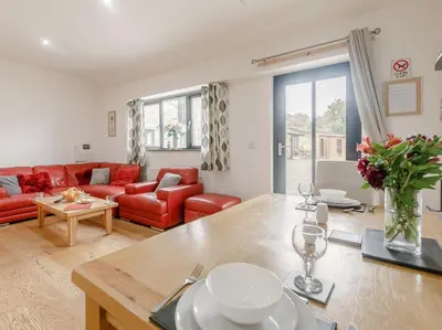 a living room with a red couch and a table at 1 Bed in Callington oc-54344 in Linkinhorne