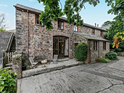 an exterior view of a brick house with two chairs at 2 Bed in Launceston oc-02038 in North Petherwin