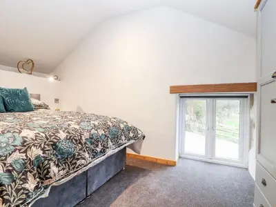 a bedroom with a bed and a window at La Petit Maison in Saint Columb Major