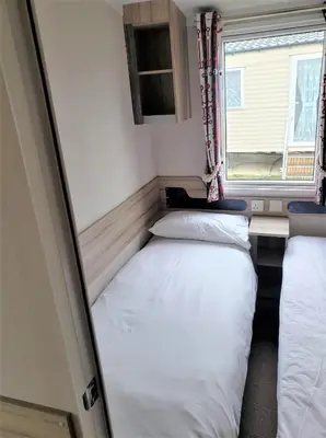 two beds in a small room with a window at Sea Break, Perran Sands, Perranporth in Perranporth