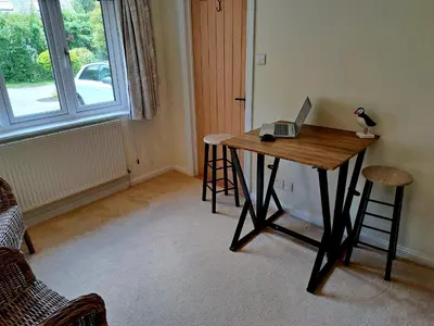 a desk with a laptop on it in a room with a window at Trevallion in Saint Endellion