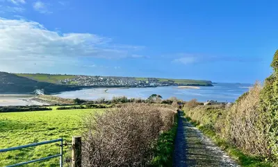 a view of a river from a hill with a road at The Roundhouse Tregonce, Padstow, near the sea in St. Issey