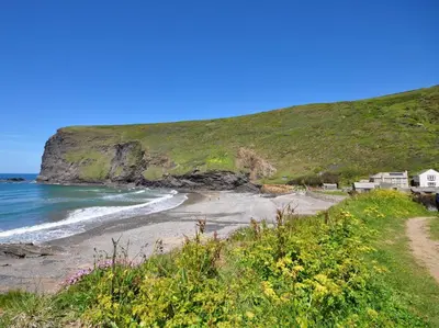 a beach with houses on a hill next to the ocean at 3 Bed in Bude oc-09117 in Saint Gennys