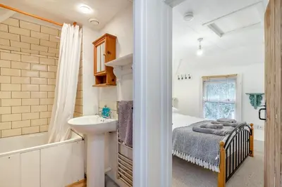 a bedroom with a bed and a sink and a tub at 2 Bed in Little Petherick oc-w28425 in Little Petherick