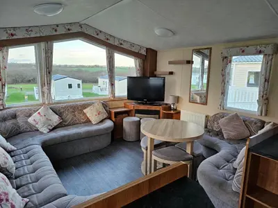 a living room with a couch and a tv at 113 Caravan at meadow lakes in St Austell