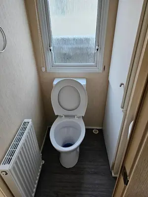 a small bathroom with a toilet and a window at 113 Caravan at meadow lakes in St Austell
