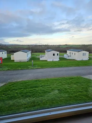 a group of white buildings on a grass field at 113 Caravan at meadow lakes in St Austell