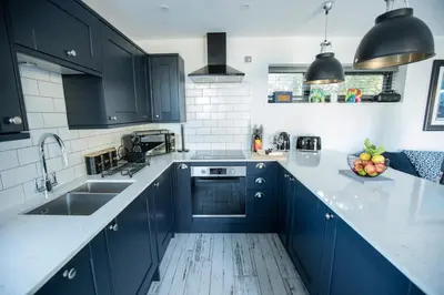 a kitchen with blue cabinets and a sink at THE ANNEXE AT UPPER BEACH HOUSE in Portreath