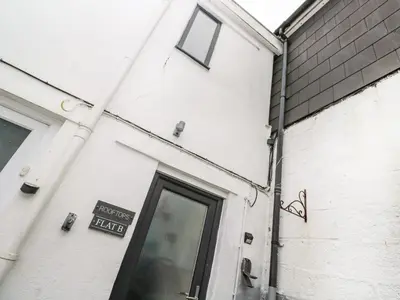 a door to a building with a sign on it at Rooftops in St Ives