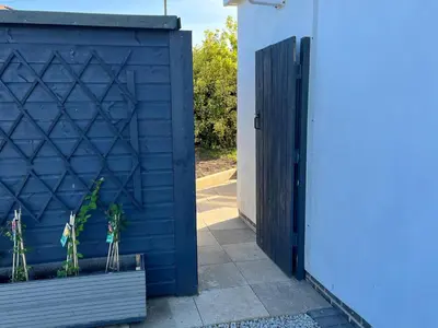 a blue garage door with a plant in a pot at Porthkidney Suite, Carbis Bay, St Ives, free parking, near beach in Carbis Bay